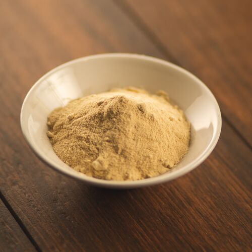 a bowl of brownulated sugar on a wooden table